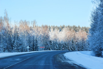 Winter. Winter road through snowy fields and forests. Winter road surrounded by snow-covered trees