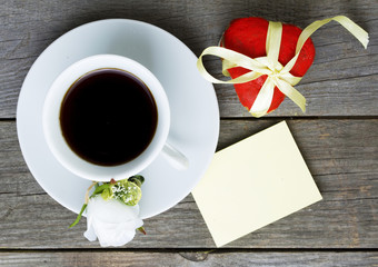 Romantic breakfast on Valentine's Day. Cup of coffee and heart shape cookies, white rose decoration, sticker for text. Toned image
