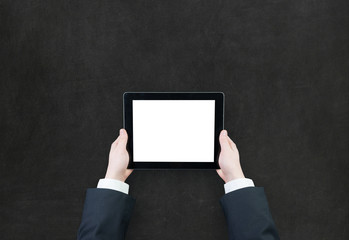 Male teen hand using tablet pc with white screen on blackboard b