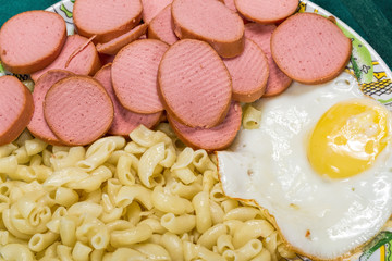 Scrambled eggs with sausage and pasta on a plate