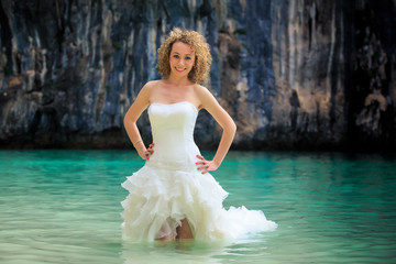 Fototapeta na wymiar closeup blonde bride in fluffy hands on waist in shallow sea