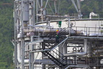 Fototapeta na wymiar oil workers with machinery pumps inside large petroleum refinery