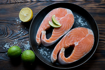 Raw fresh salmon fillets with sea salt, lemon and lime, close-up