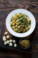Potato gnocchi with pesto sauce in a rustic wooden setting