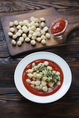 Italian gnocchi with tomato sauce in a rustic wooden setting