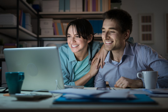 Happy young couple surfing the web at home