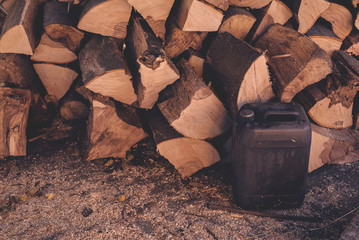 Firewood pile and plastic oil canister