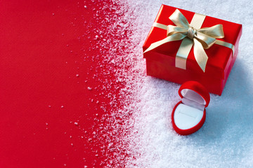 Valentine gift and jewelry box on white snow winter and red background. St. Valentines Day concept...