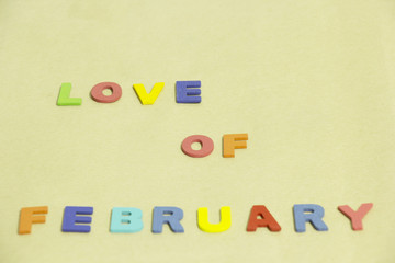 Colorful word "Love of February"  on Brown background. selective