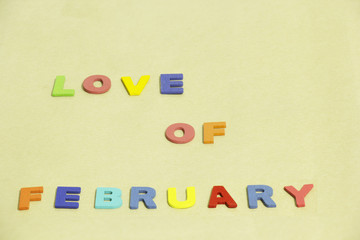 Colorful word "Love of February"  on Brown background. selective