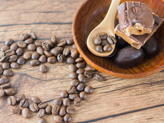 Coffee beans arranged heart figure with spoon and chocolate bars