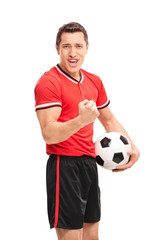Happy football player holding a ball