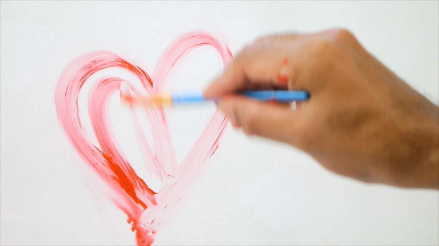 Artist paint two red heart shape on glass white background