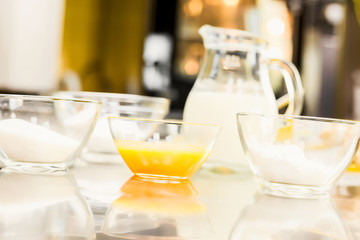 Glassware with eggs, sugar, flour. Jug vodoy.Na kitchen. In the confectionery shop.