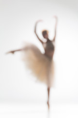 Blurred silhouette of ballerina on white background