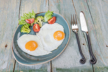 Two fried eggs and vegetables