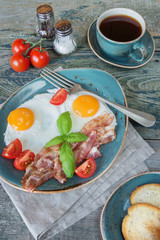 Fried eggs,  bacon, tomato, toast and a cup of coffee
