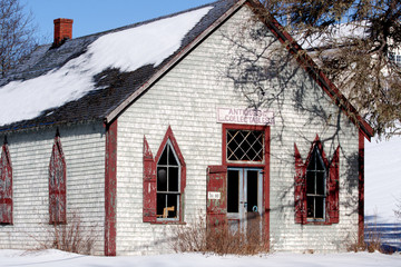 old house front with red door and windows and sign