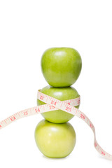 Stacked apples with a tape measure, isolated on white