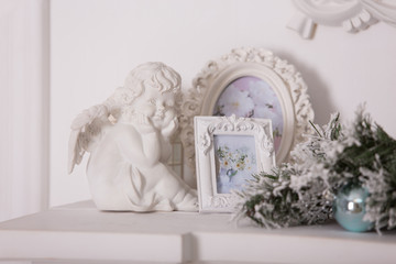 white framework for photos and a figurine of an angel