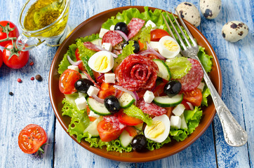 Salad with fresh vegetables, feta cheese, quail eggs, olives and