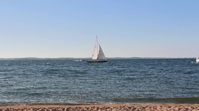 Sailing the ocean in the summer, France - Full HD. Sailboat crossing the horizon. View from the beach of Arcachon (France). Static shot on a summer's day. 1080p