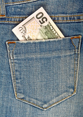 Fifty American dollars bill sticking out of the back jeans pocke