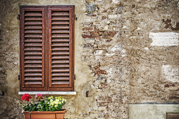 Fototapeta na wymiar brown window shutters in a rustic wall