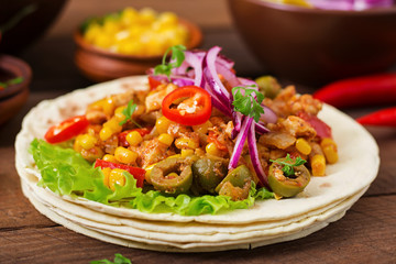 Mexican tacos with meat, corn and olives on wooden background.