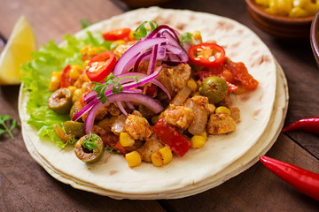 Mexican tacos with meat, corn and olives on wooden background.