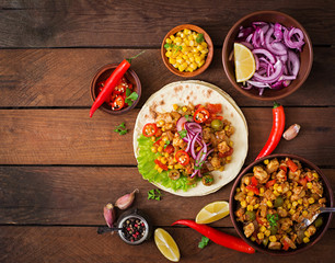 Mexican tacos with meat, corn and olives on wooden background. Top view
