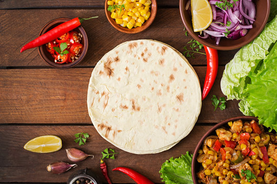 Ingredients for Mexican tacos with meat, corn and olives on wooden background. Top view