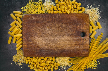 Set of pasta on a dark background/Spaghetti, penne, pipe, gemelli, fusilli, gnocchetti, risoni, stelline. Italian food frame. Place for text or logo