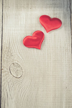 Two hearts hanging on wooden background