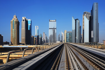 Fototapeta na wymiar Metro on the background of skyscrapers of Dubai World Trade cent