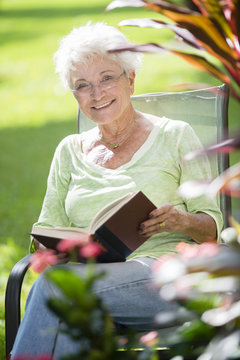 Senior Caucasian Woman Reading Book Outdoors