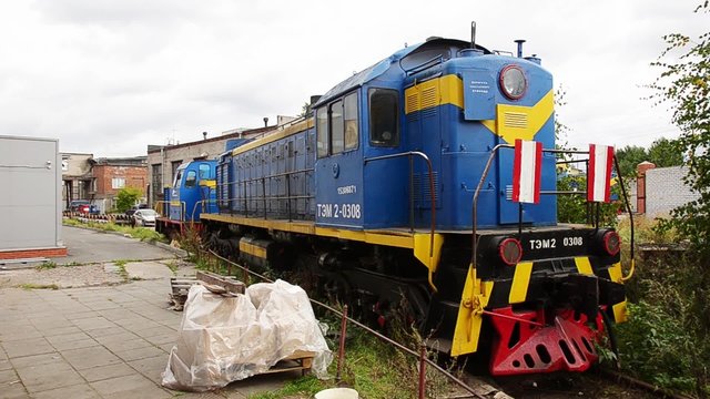 Abandoned bright vintage railway carriage stays in the depot on the ground.
