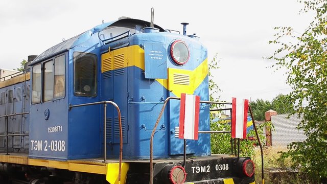 Abandoned bright vintage cabin of engine driver stays on a ground in the depot