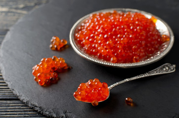 Red salmon caviar on black background