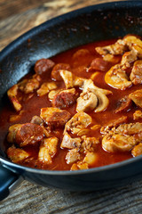 Chicken meat and chorizo cooking in the frying pan