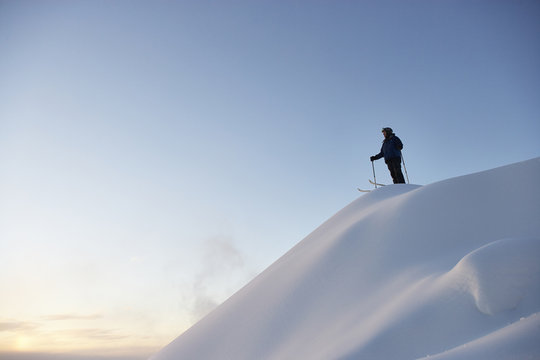 Caucasian skier standing on snowy hilltop