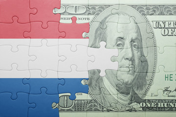 puzzle with the national flag of netherlands and dollar banknote