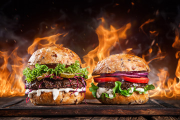 Home made burgers with fire flames. - obrazy, fototapety, plakaty