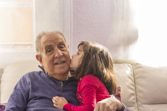 Portrait of a grandfather sitting smiling with his granddaughter