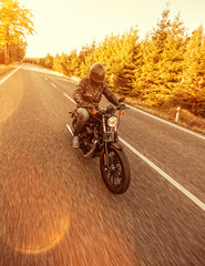 Obraz premium Man seat on the motorcycle on the forest road.