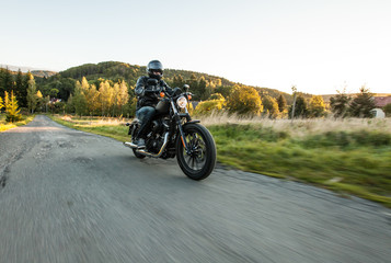 Naklejka premium Siedzenie człowieka na motocyklu na leśnej drodze.
