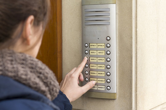 Woman  calling on the intercom and presses the button