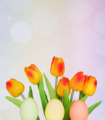 Colored Easter Eggs and Tulips on a Colorful Background