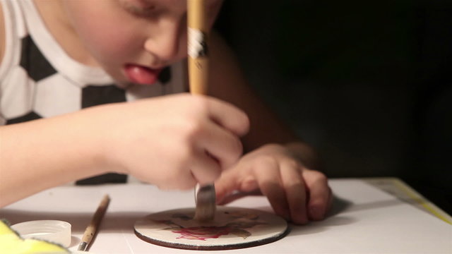 Creative little fella paints a coaster to make a decoupage product
