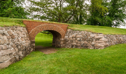 Fototapeta na wymiar Historical site of yesteryear, a brick archway supports an overpassing route, formerly used by soldiers to patrol this historic site in Nova Scotia, Canada.